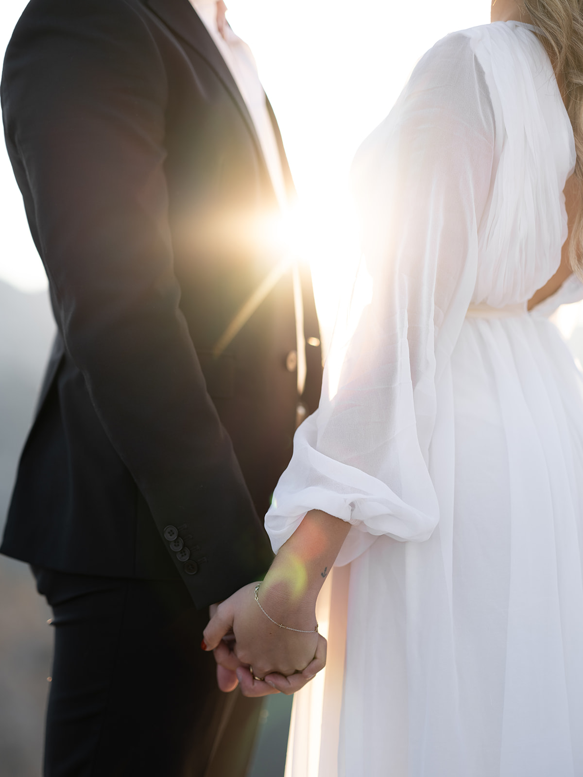 couple holding hands during sunset on their wedding day 