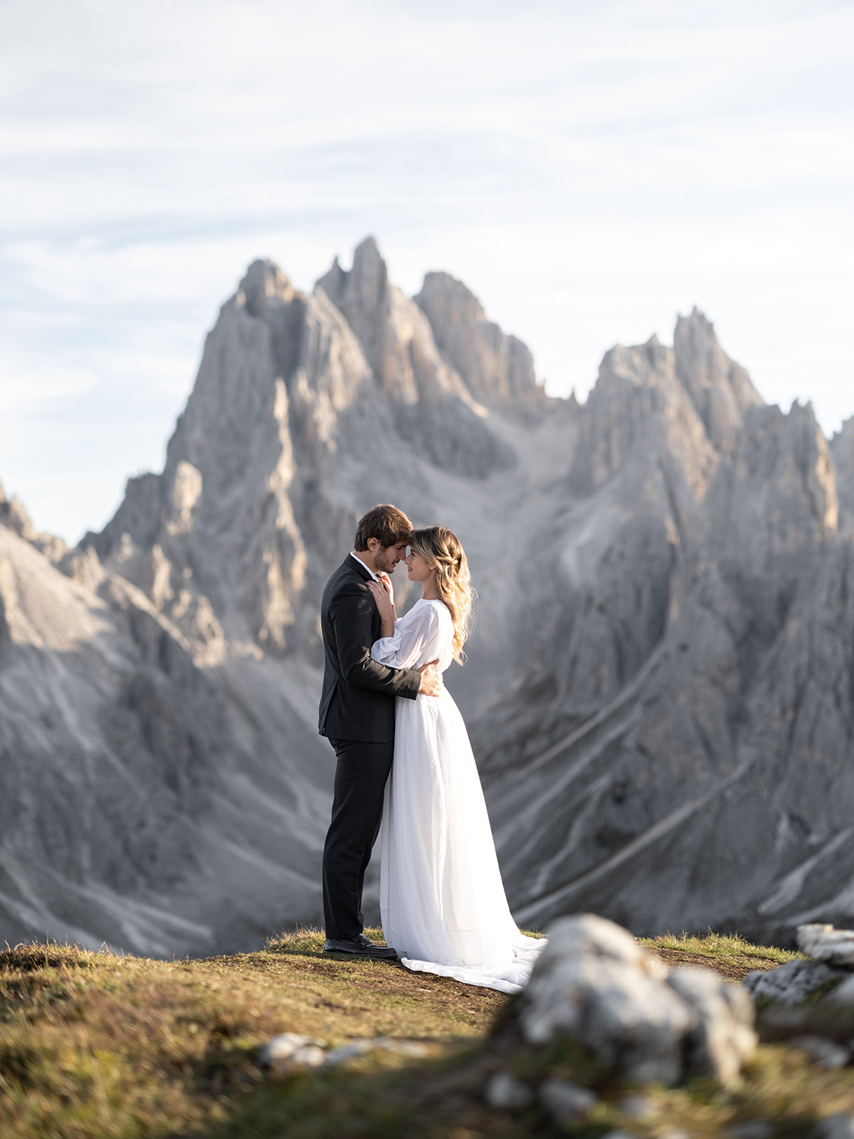 couple kissing with the dolomites in the background during their wedding day 