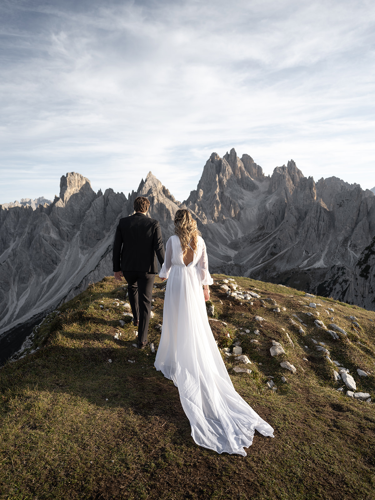 couple walking in the dolomites on their wedding day