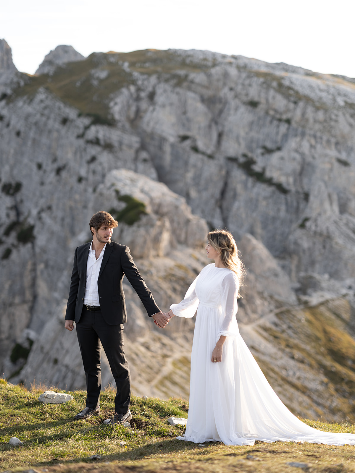 couple walking in their wedding attire at the dolomites 