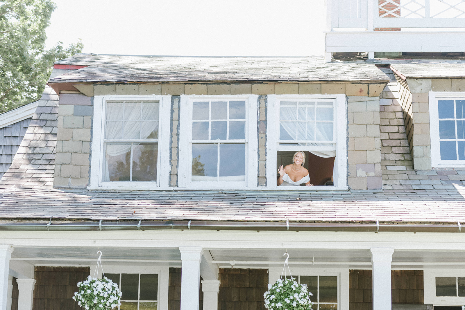 Photo os a Bride waving  from a window on her wedding day at the water Witch Club in NJ