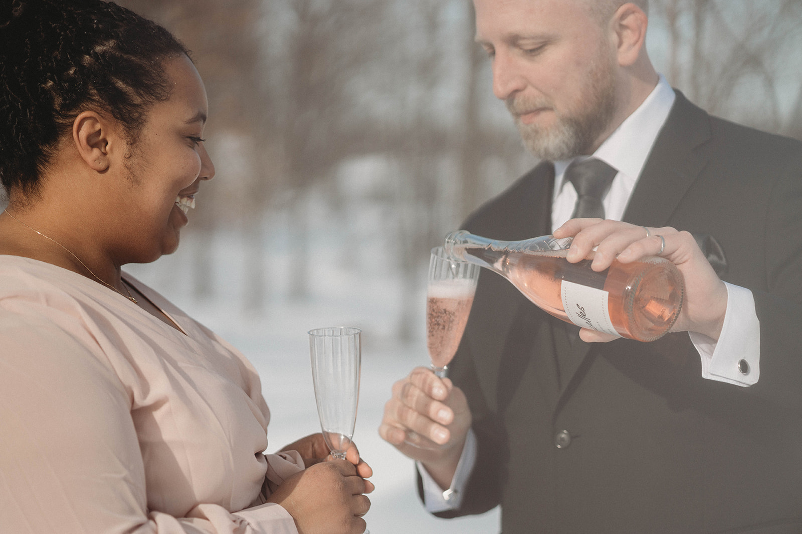 A couple who eloped in Montreal, Canada celebrate after their adventure wedding with a glass of champagne