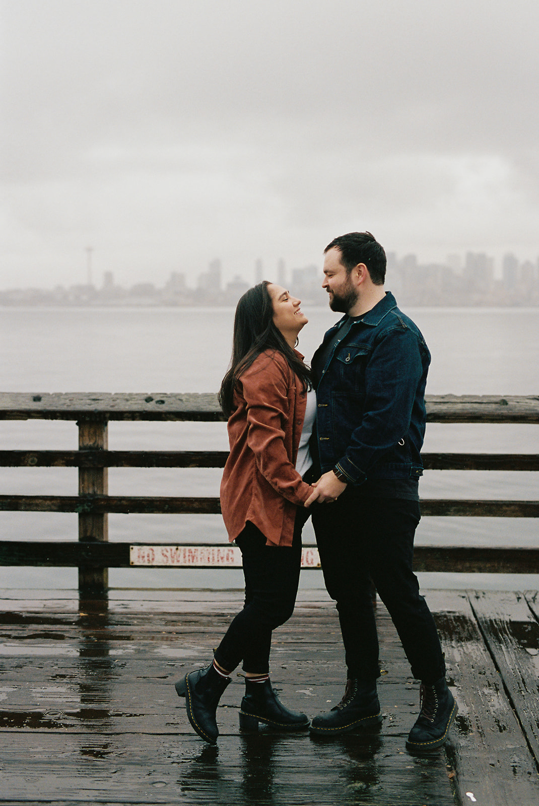 portra 400 photograph of a couple embracing on a rainy day on a pier
