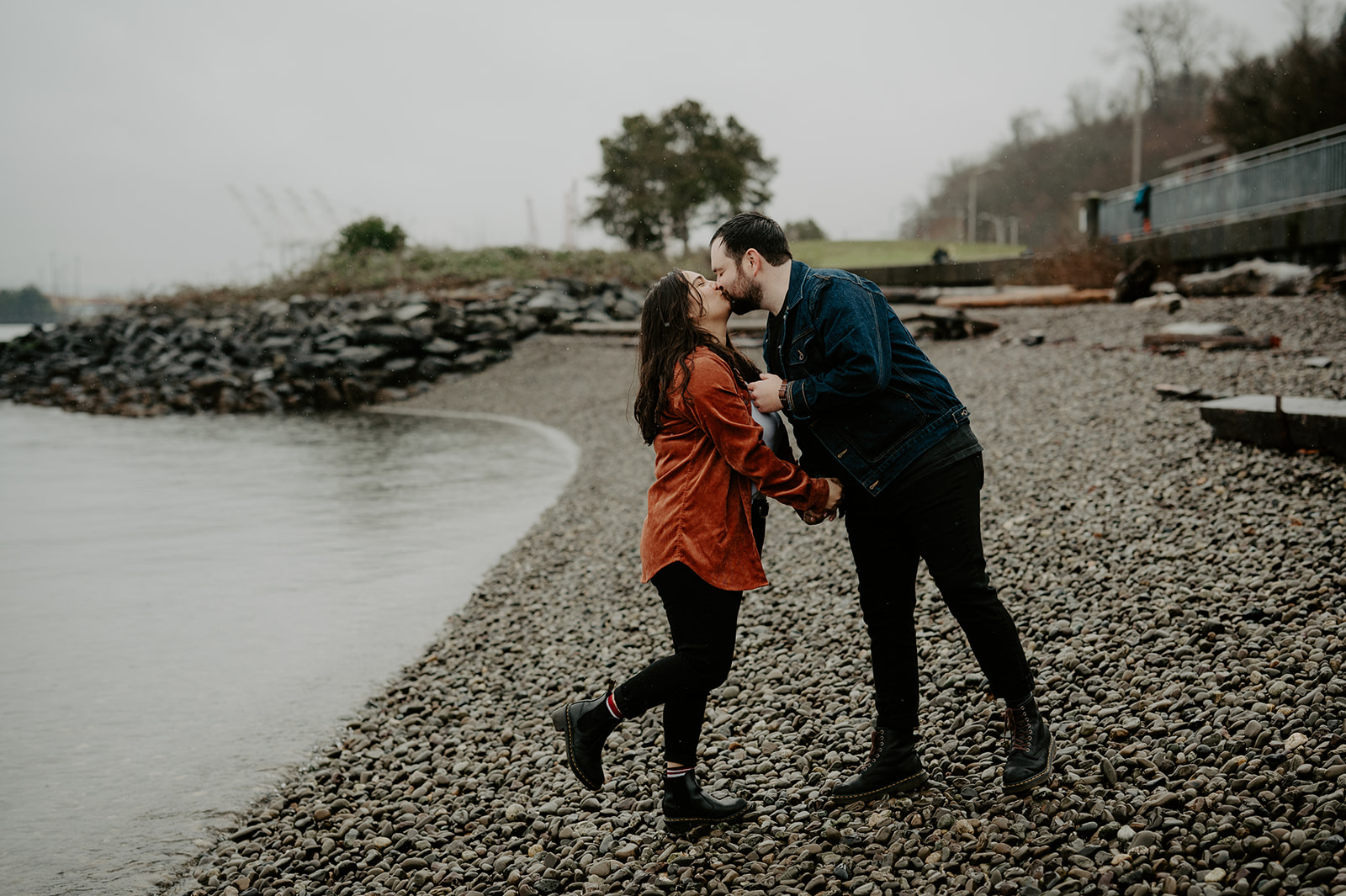 a couple kisses in the rain at the beach