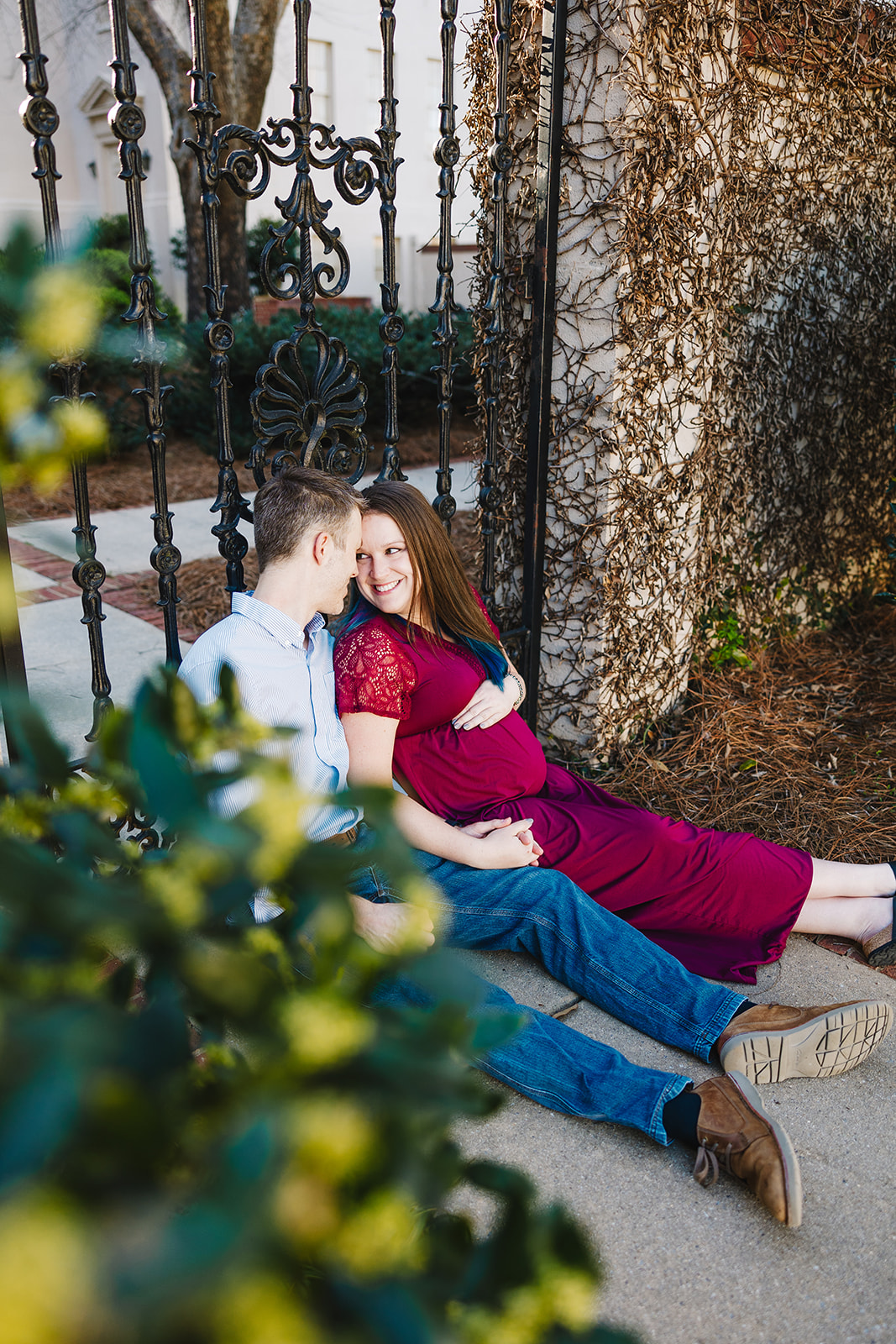 sitting maternity pose of couple in downtown Athens ga