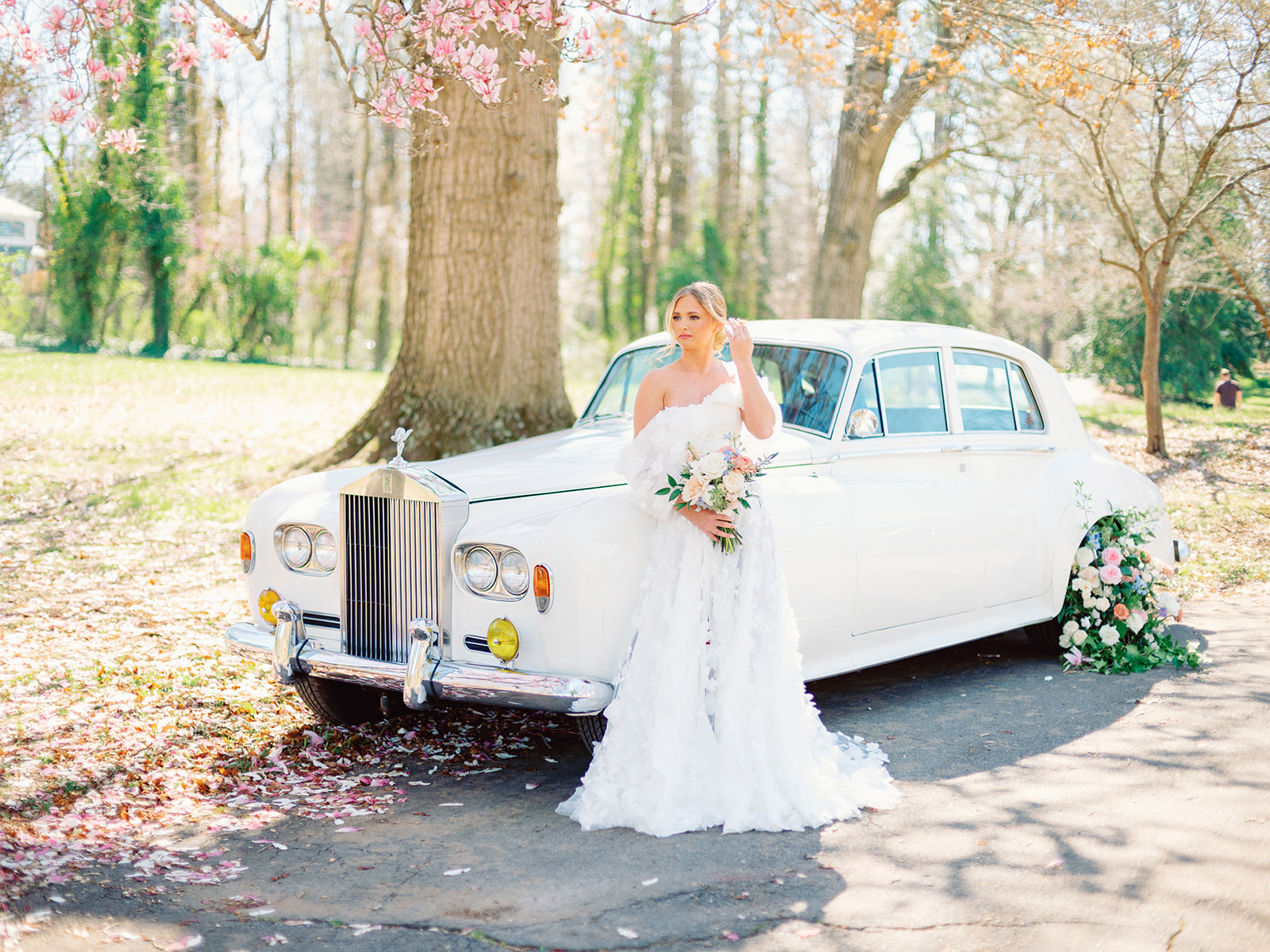 Bride standing in front of classic rolls-royce car