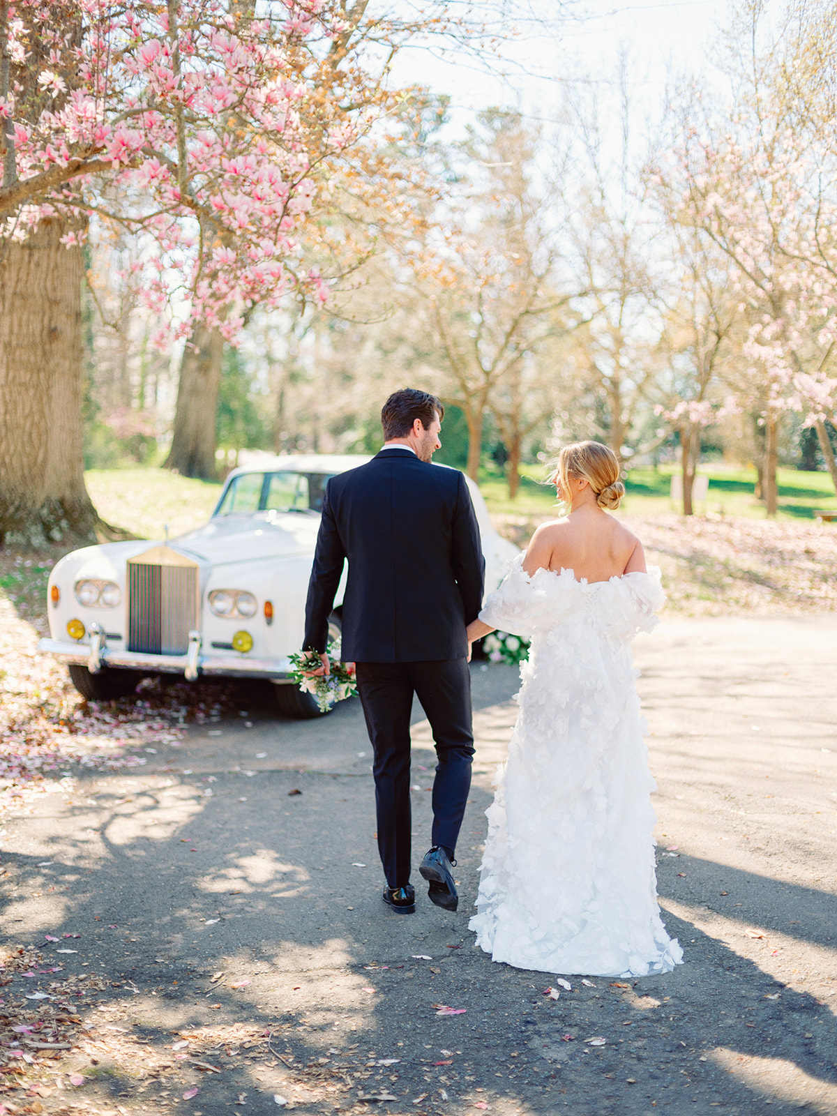 Couple walking away from classic rolls-royce car
