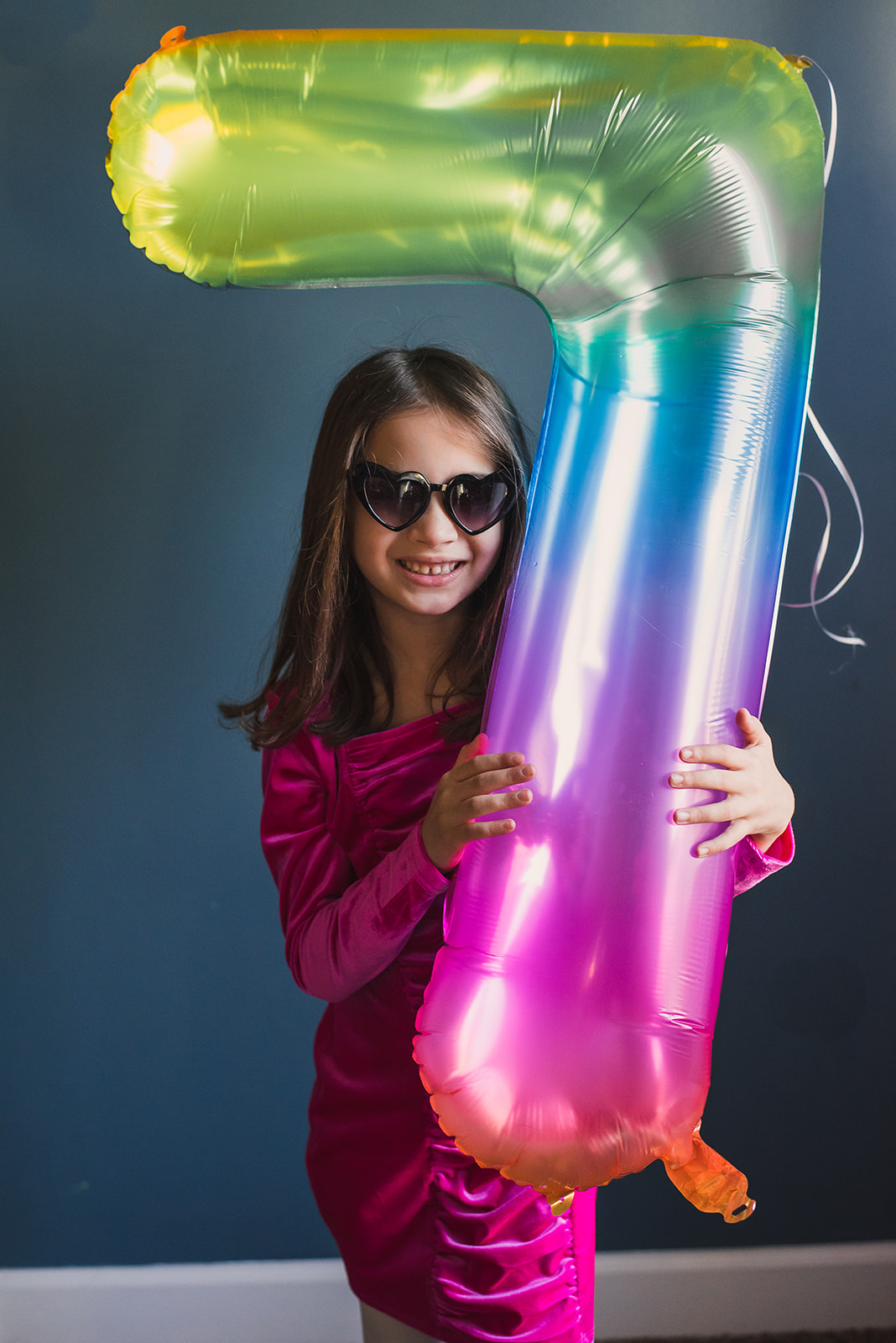 Little girl holding 7 balloon