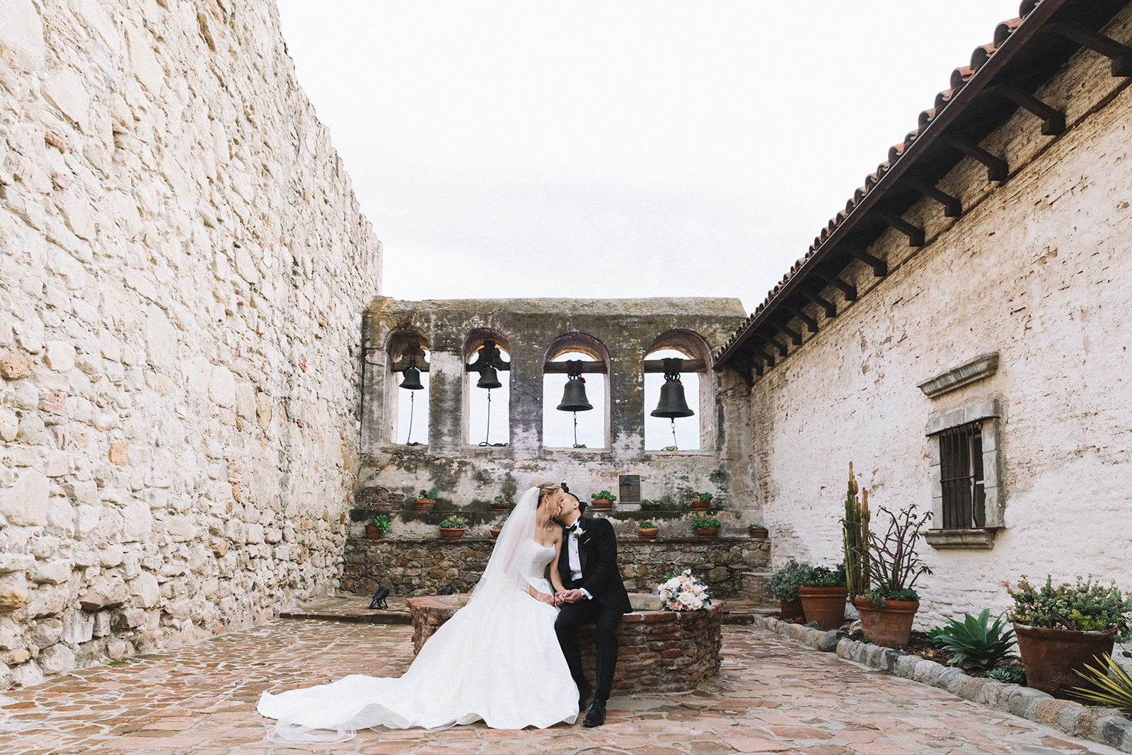 Couple has a wedding portrait session at the Mission San Juan Capistrano in San Juan Capistrano, California. 