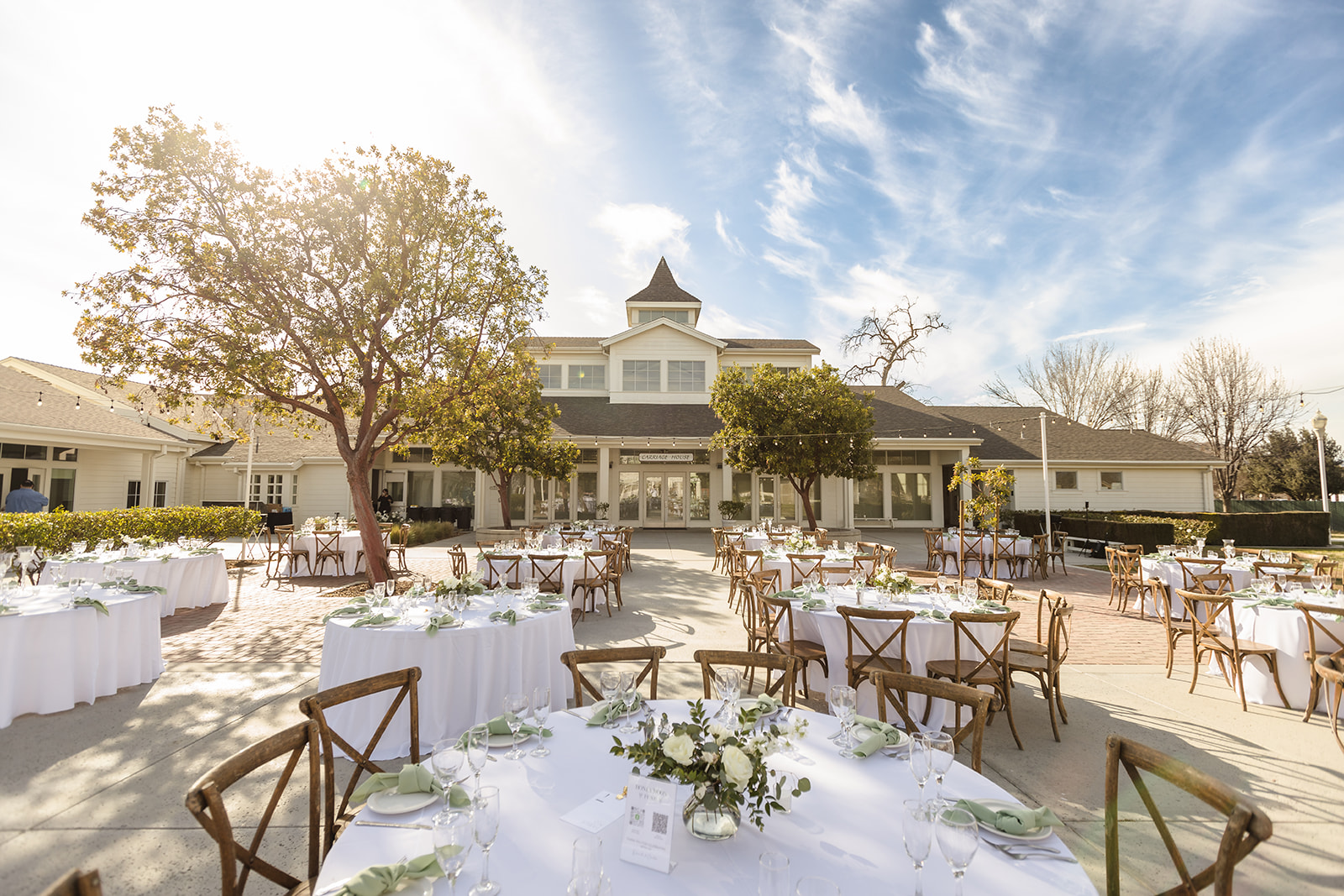 Outdoor courtyard wedding reception at Crestmore Manor with white and sage green decor.