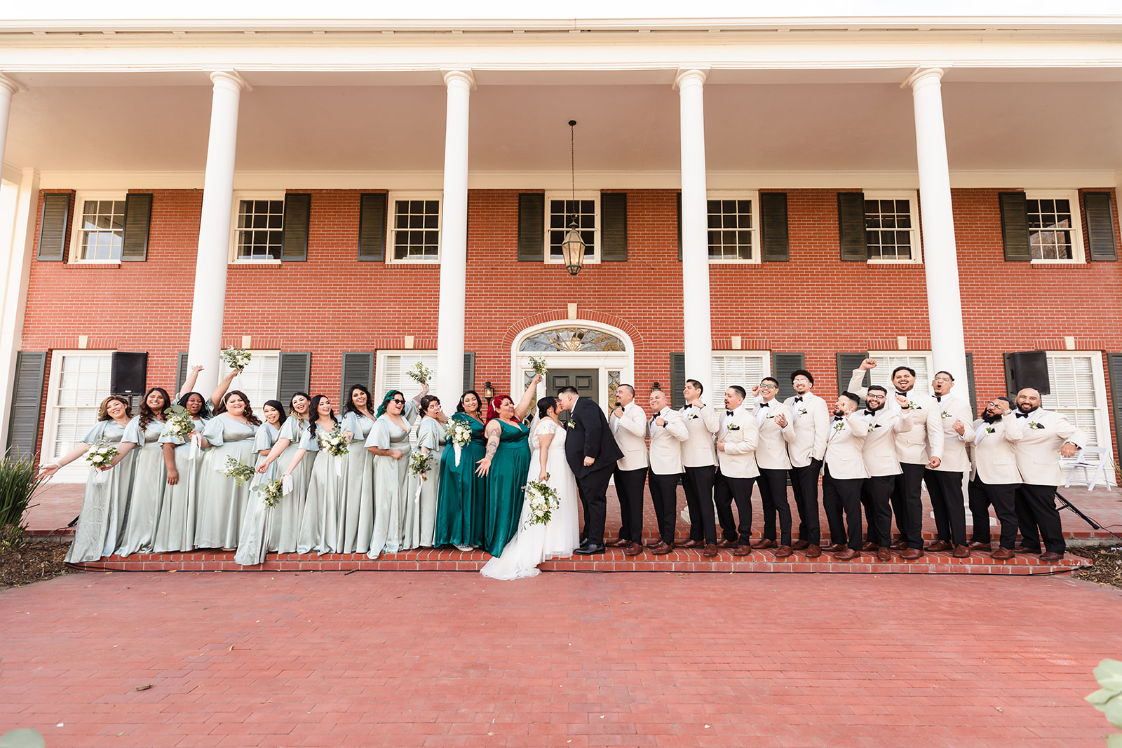 Bridal party cheers for the newlyweds on the front steps of Crestmore Manor