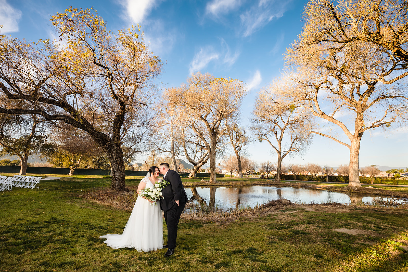 Bride and groom in front of lake at Crestmore Manor, Jurupa Valley