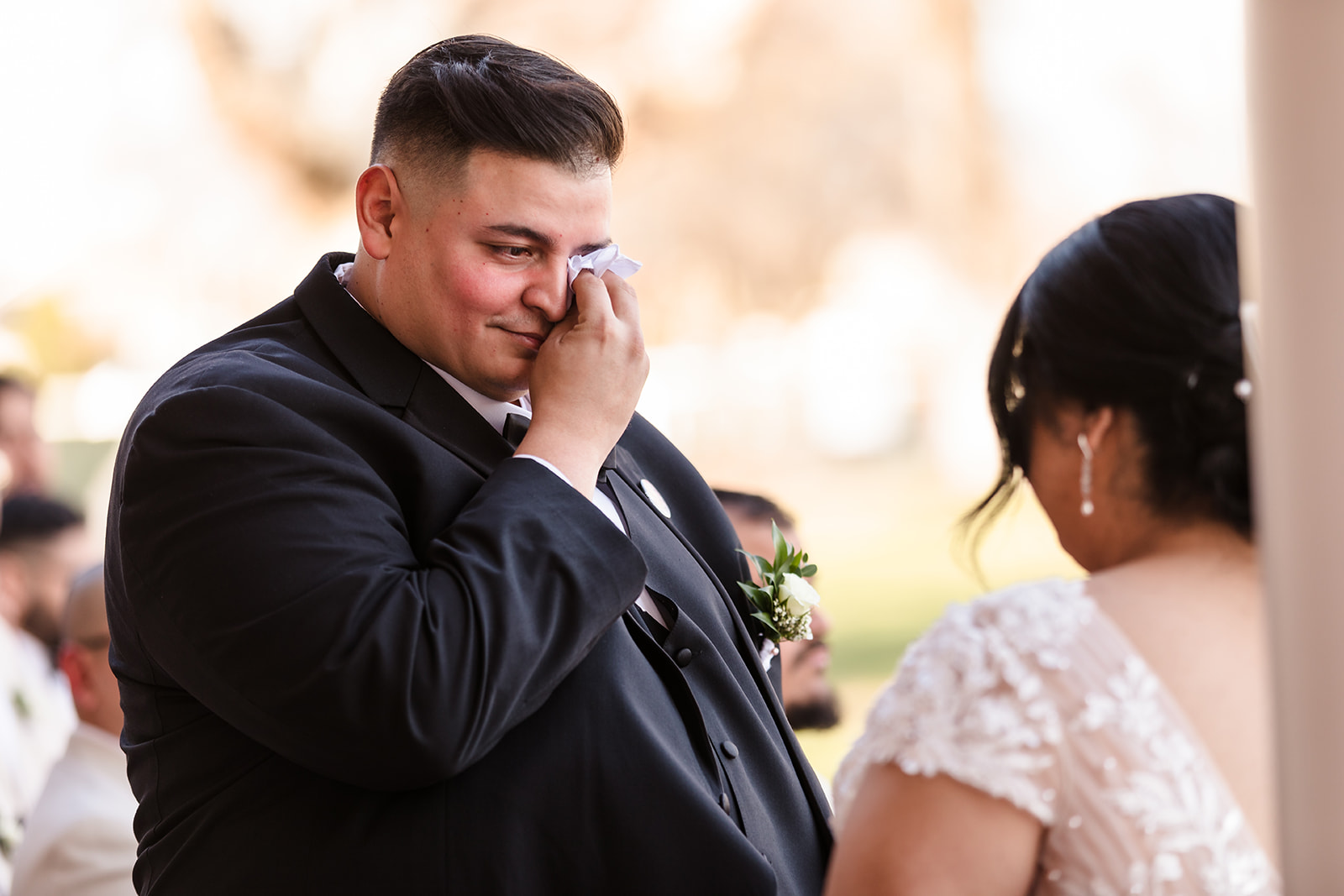 Groom wipes away a tear during the ceremony