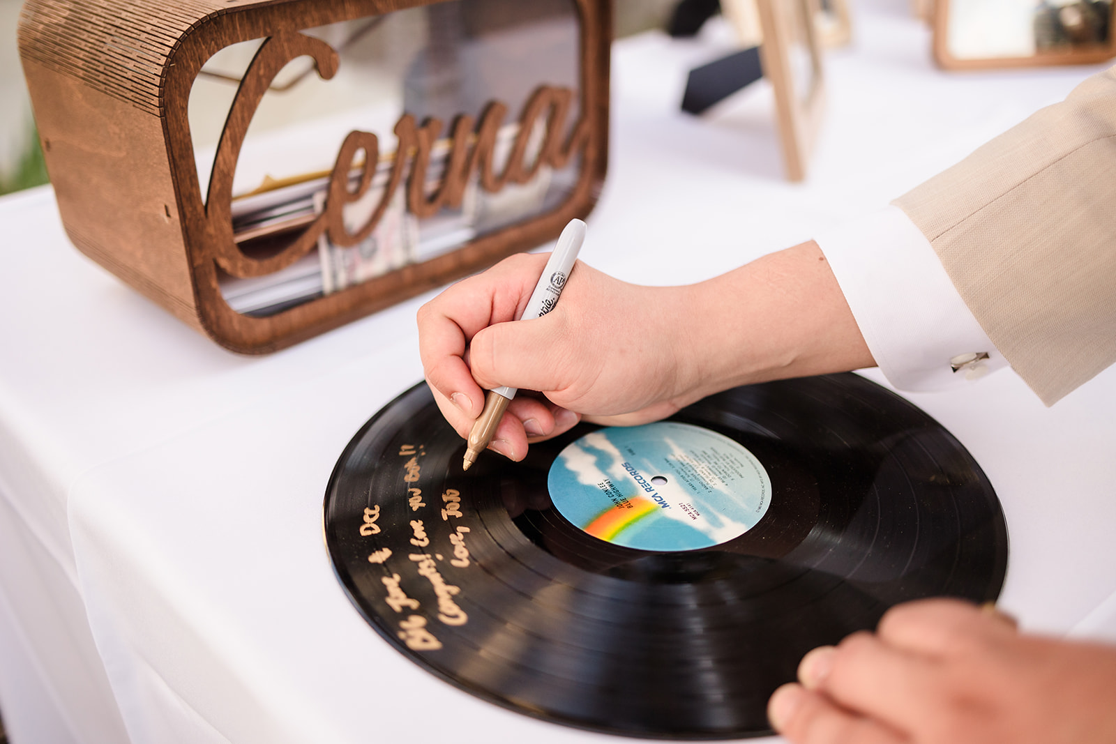 Guests sign vinyl records as a unique wedding guestbook alternative