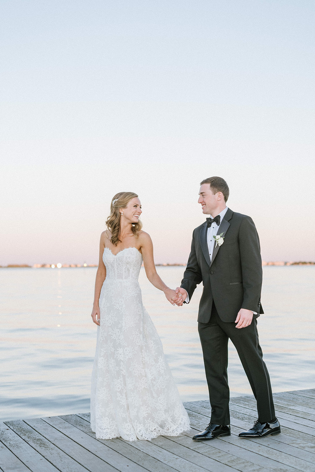 Bride and groom walk on the dock at Rumson Country Club Riverhouse
