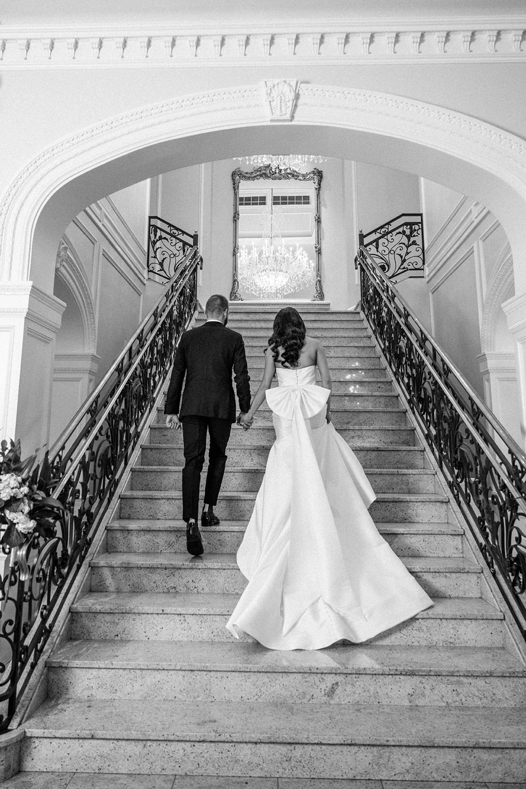 Bride and groom walk up grand staircase at The Rockleigh