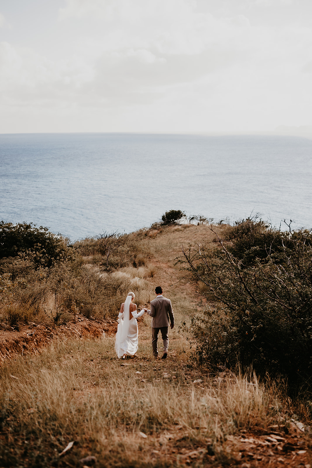 Bride and groom walking hand in hand along the pristine shores of the British Virgin Islands