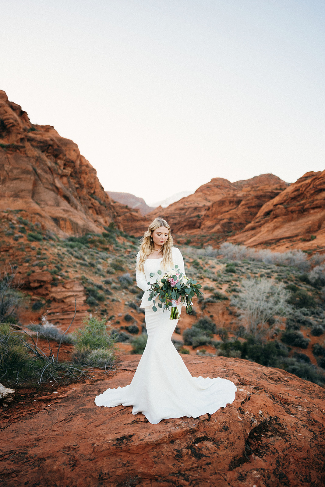 bride with bouquet in red rocks