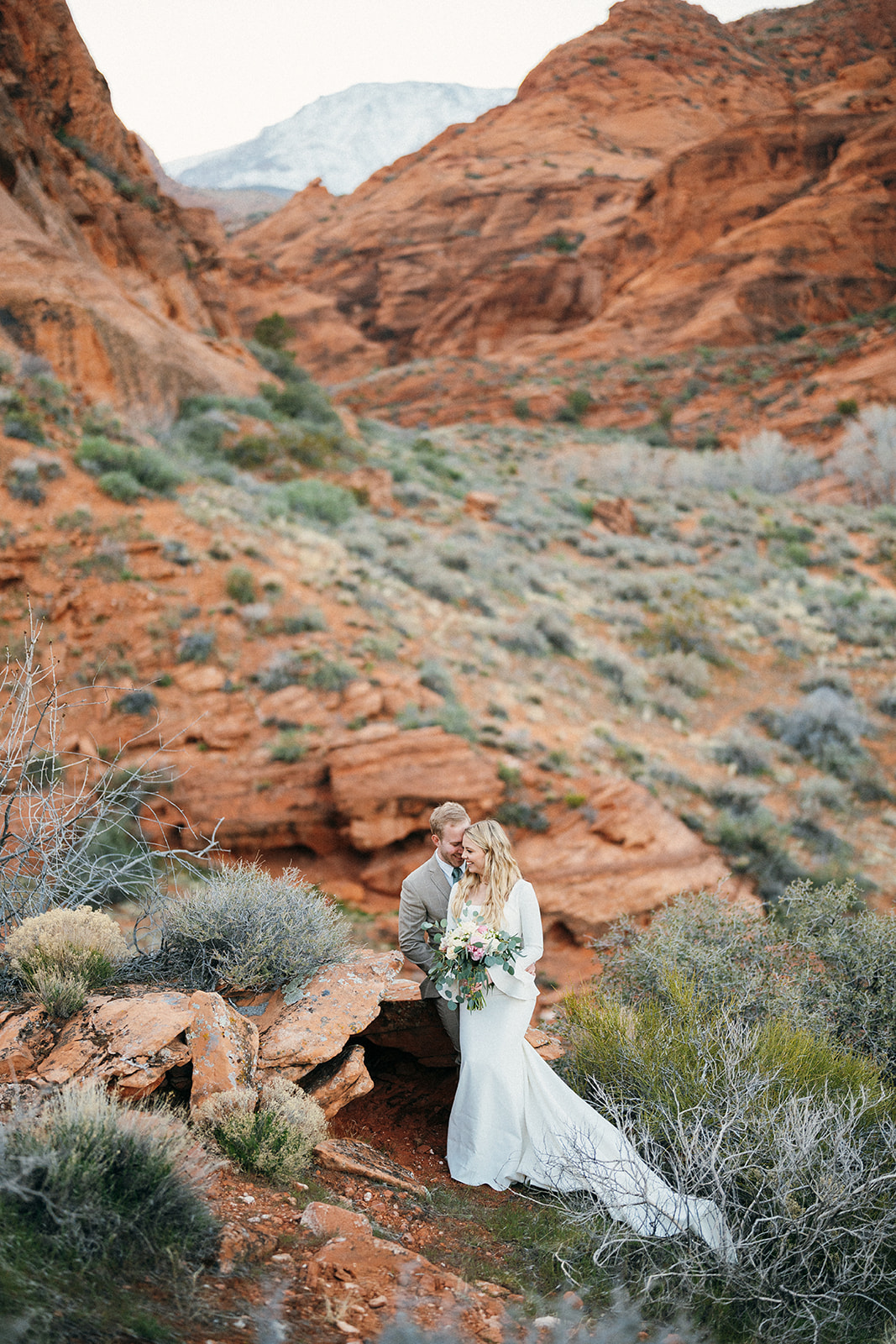 wedding couple sitting on bedrock in canyon