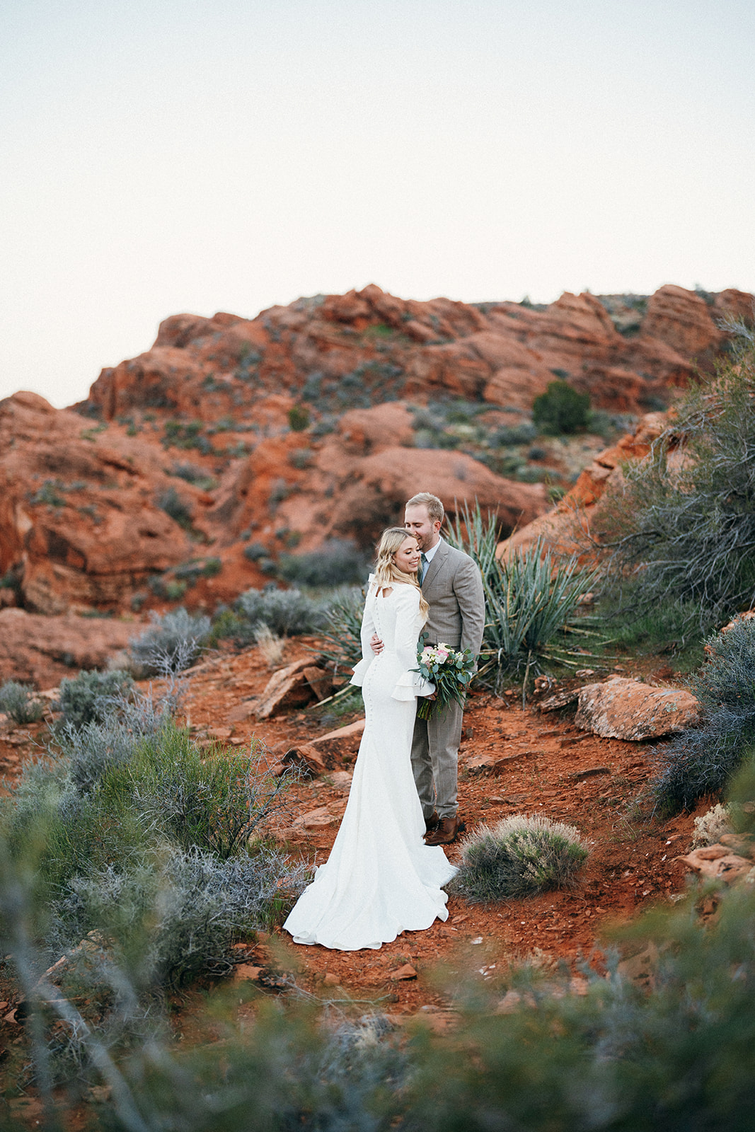 wedding couple standing together in desert