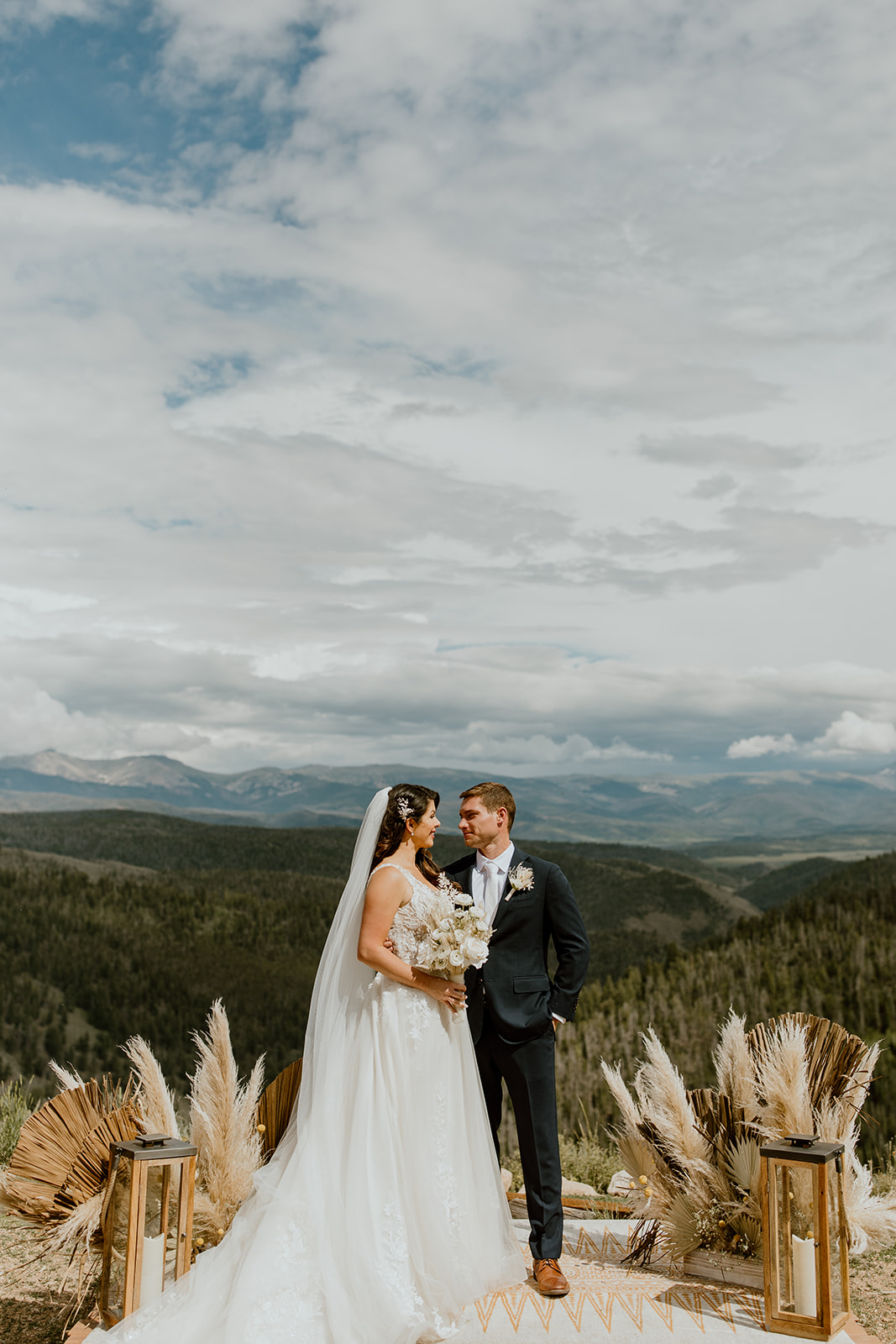 Couple poses on a Colorado mountain top for their wedding portraits