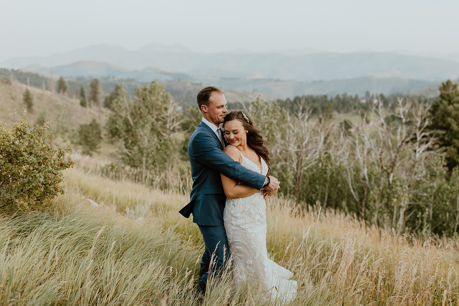 Groom hugs his new wife with the hills of Boulder, Colorado in the background. 