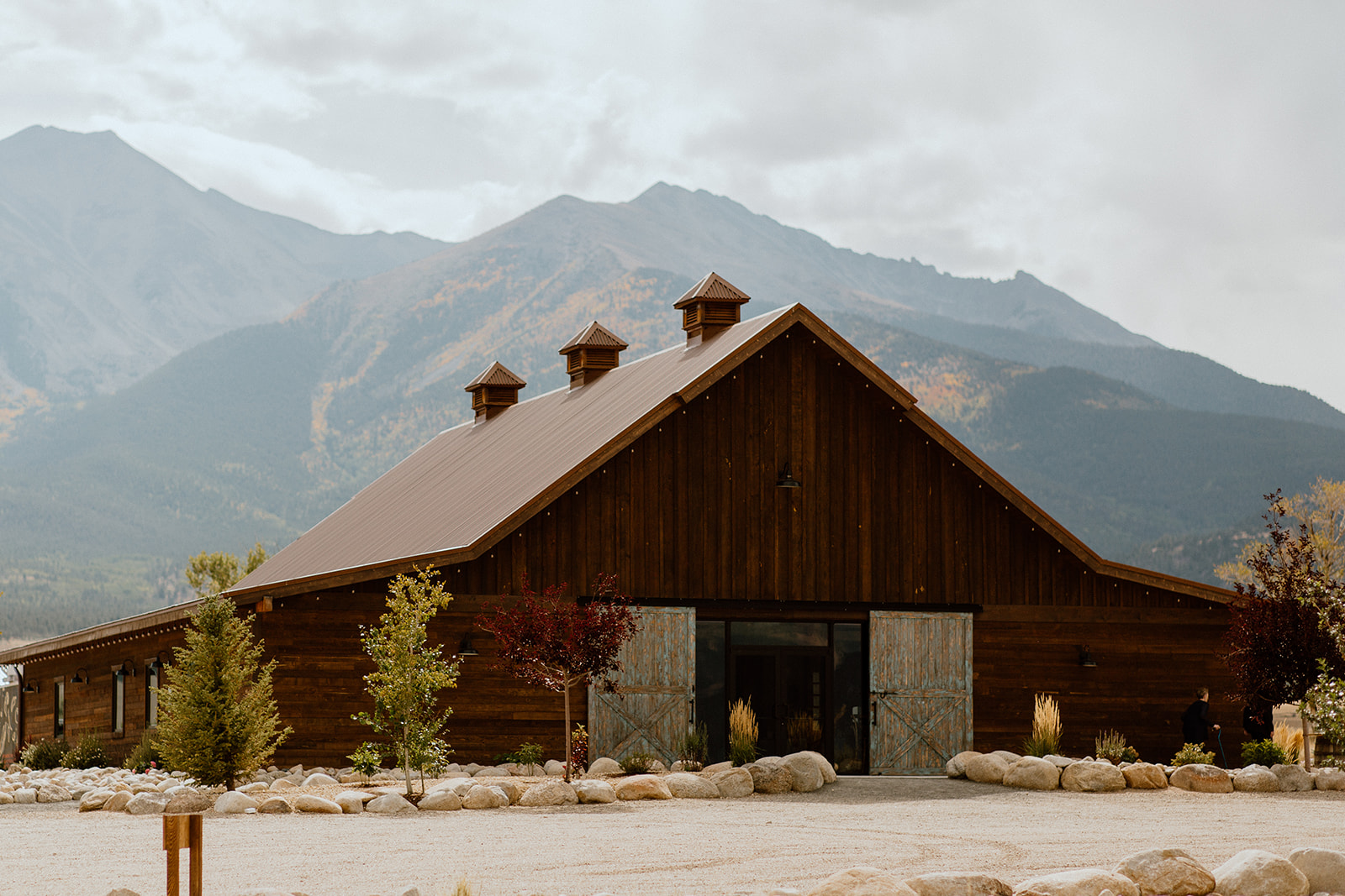 Brown barn wedding venue with Collegiate Peaks in the backdrop. 