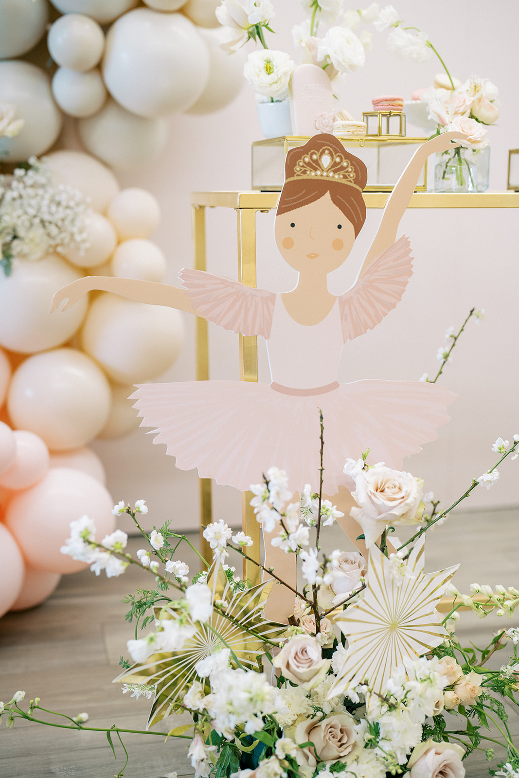 Ballerina character cutout with florals and balloons.