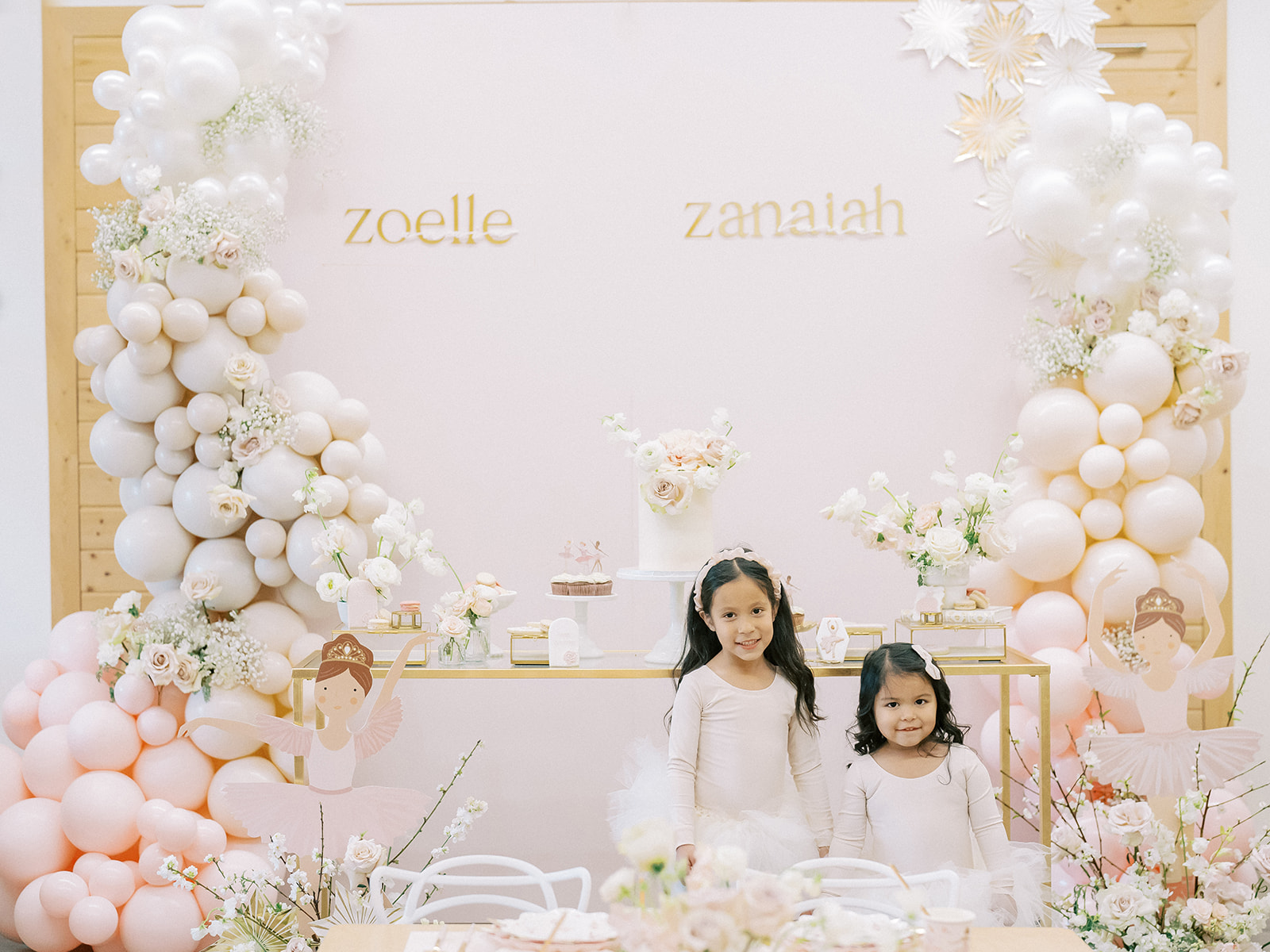 Ballerina birthday girls in front of their themed backdrop.