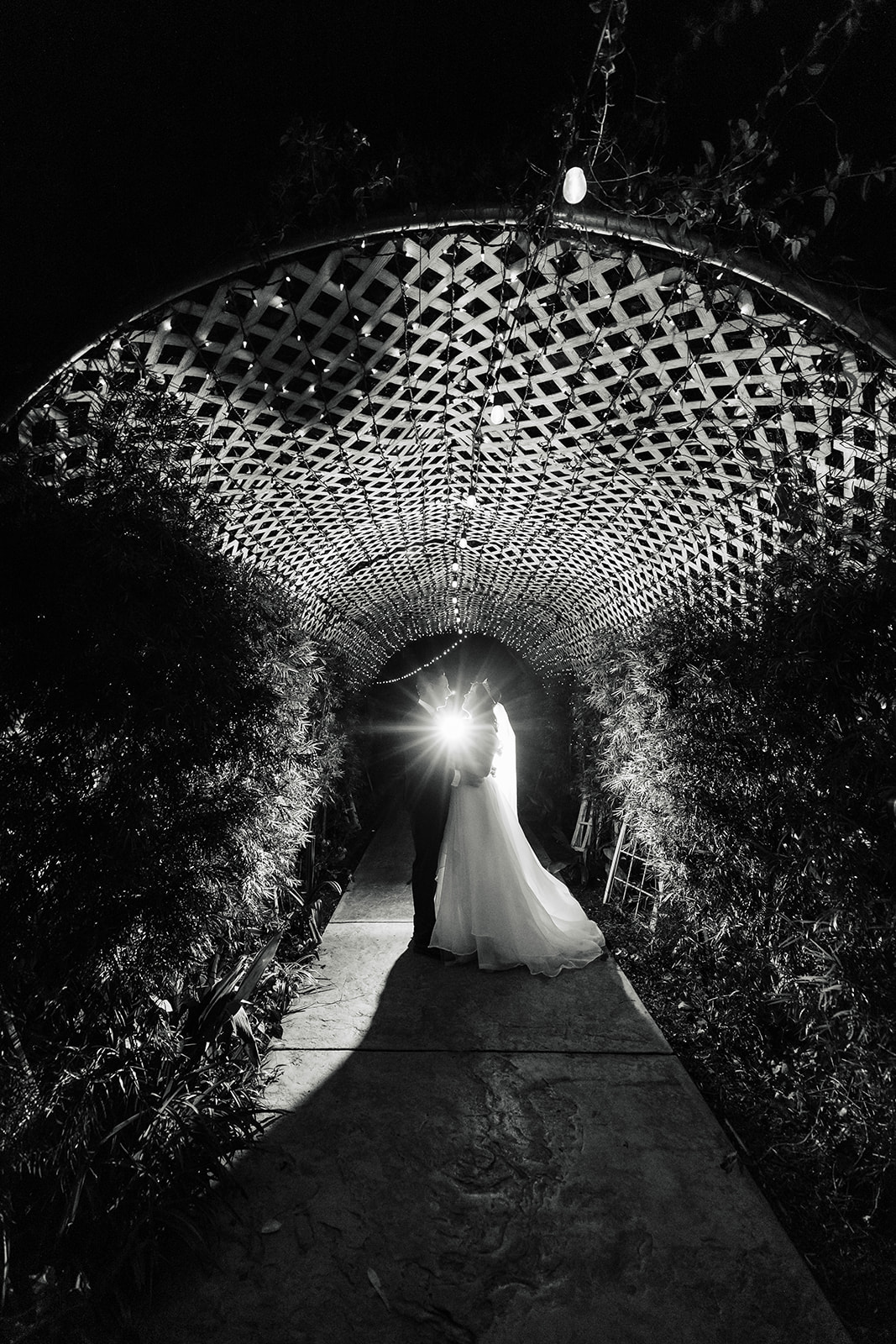 Black and white photo of the bride and groom in the tunnel at The Orchard
