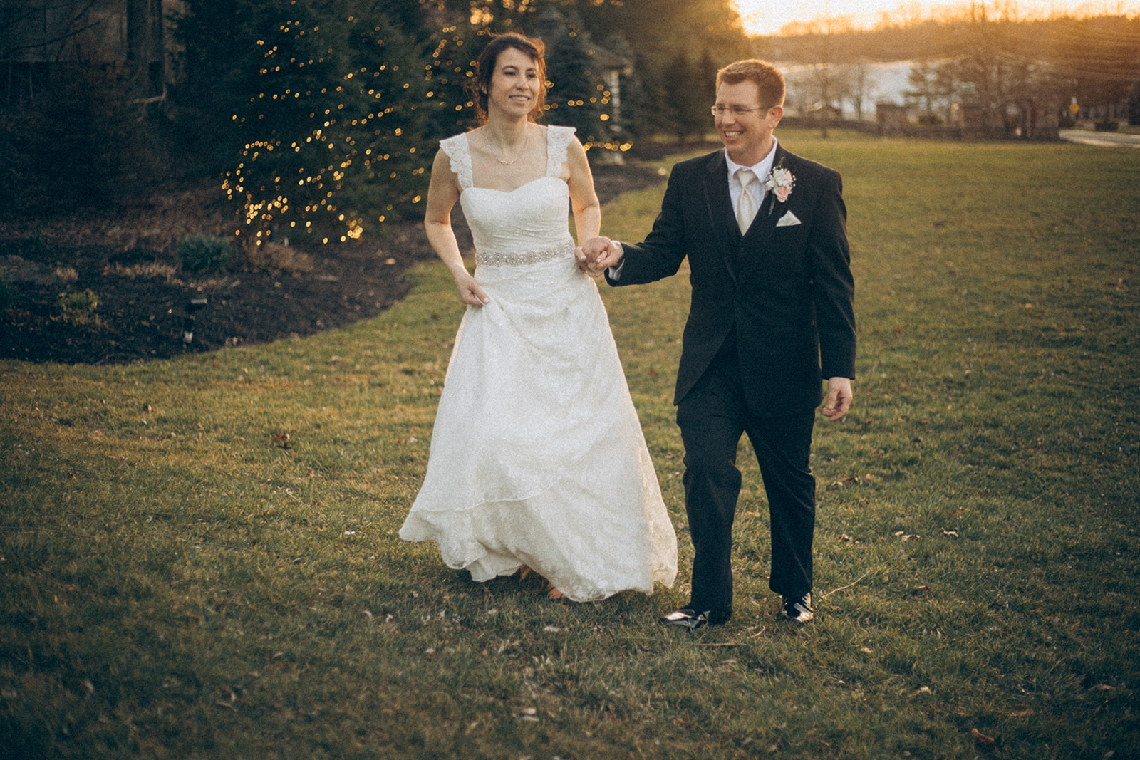 bride & groom having a romantic walk on the grassy front lawn of the woodwinds new haven wedding photographer