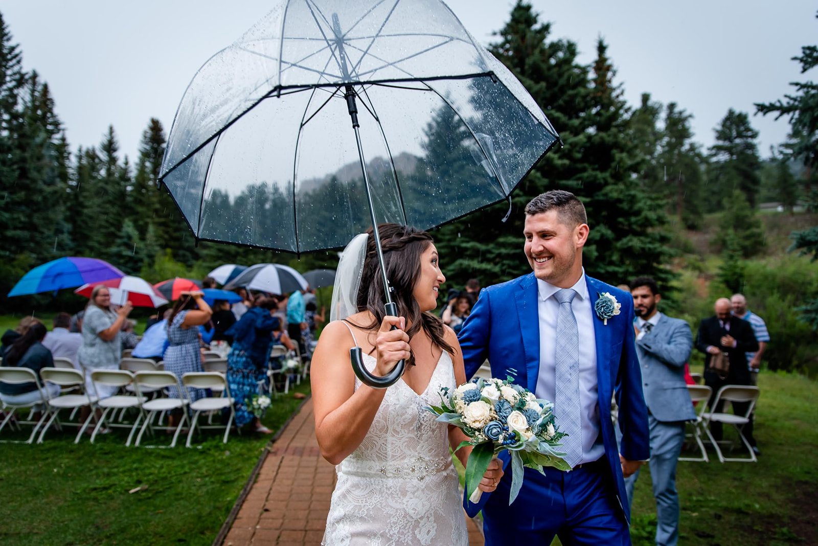 a couple happily exits their rainy wedding ceremony at Wedgewood mountain view ranch in Colorado