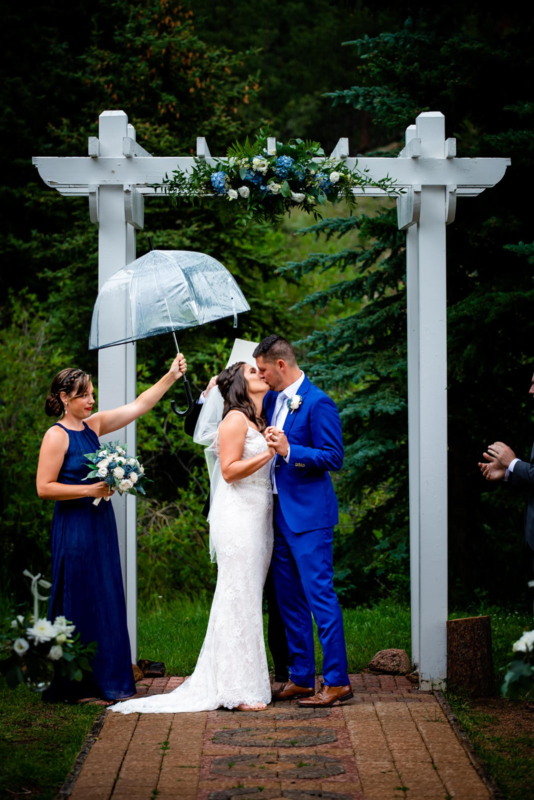 a couple has their first kiss at their outdoor wedding ceremony in Colorado in the rain