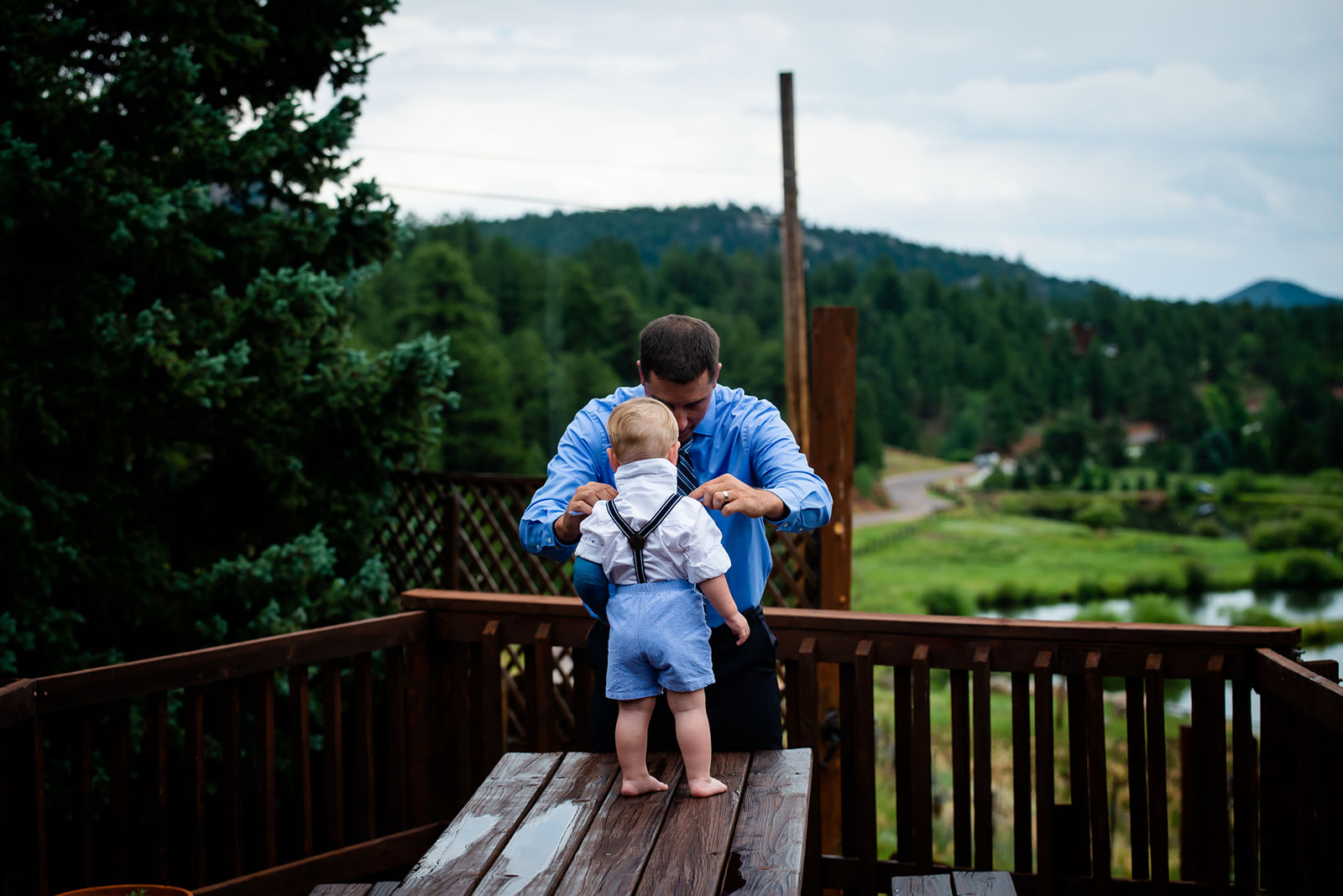 a dad finishes getting one of the ring bearers dressed for a wedding at Wedgewood mountain view ranch