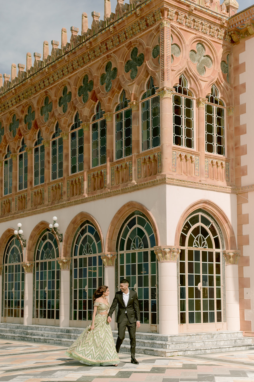 "Indian bride and groom in traditional attire showcase their love and beauty at the Ringling Museum's Ca' d'Zan mansion"