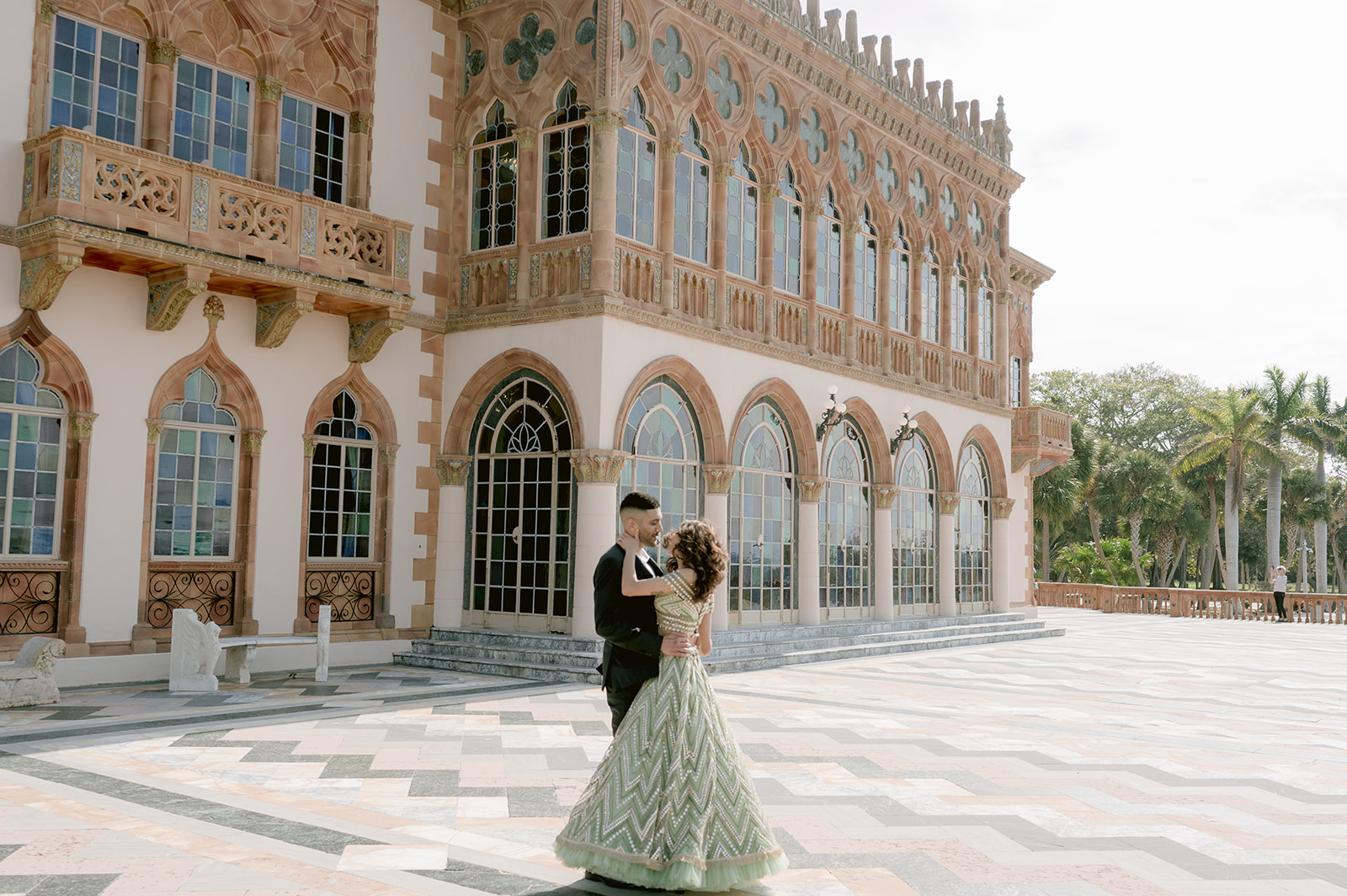 "Indian couple in traditional attire poses in front of the magnificent Ca' d'Zan mansion"

