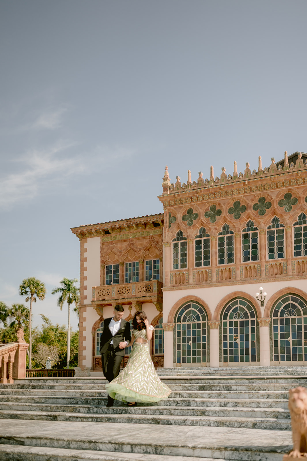 "Indian couple in traditional attire showcases their love and cultural heritage at the Ringling Museum's Ca' d'Zan mansi