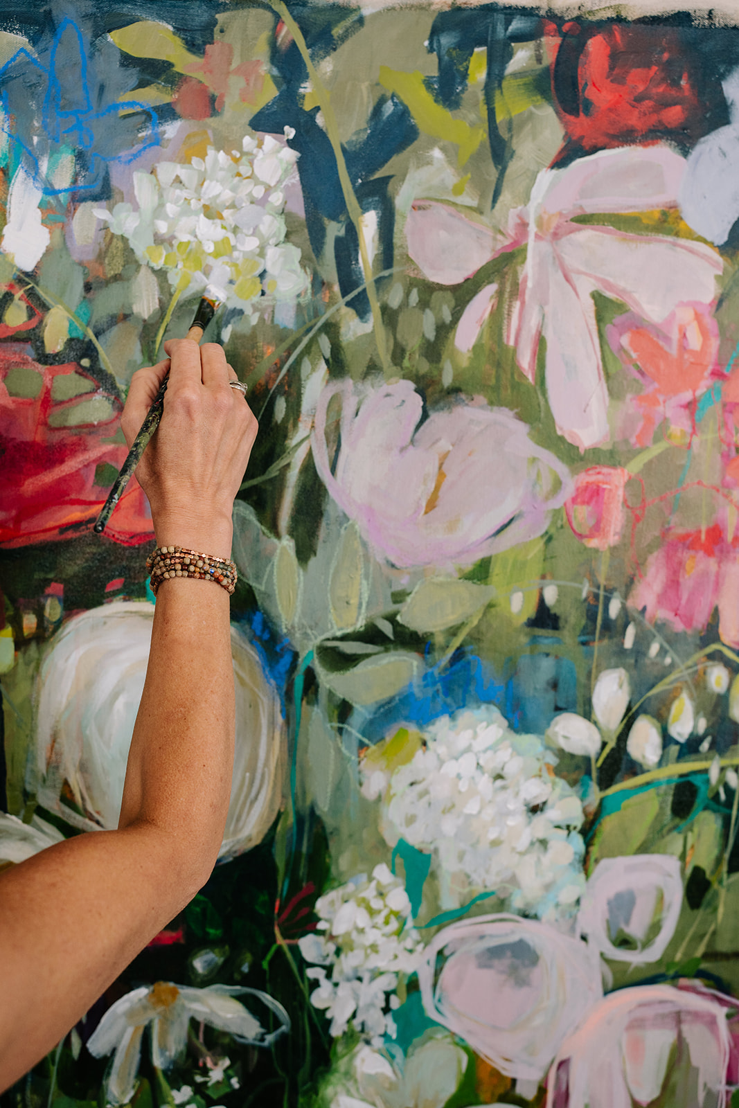 woman's arm painting floral canvas