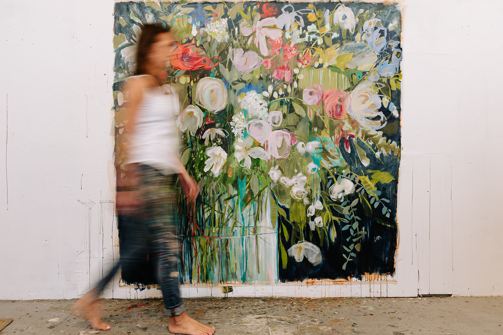 blurry woman walking past giant floral canvas