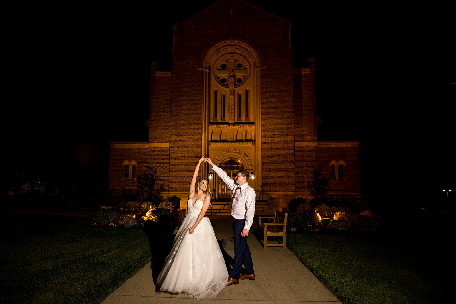 Wedding couple dance at nighttime in front of their Catholic church in Northern Kentucky