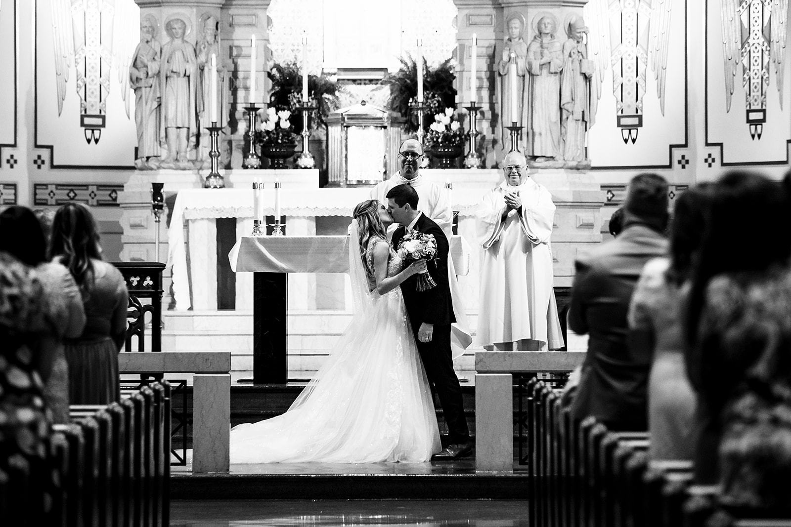 Wedding couple share first kiss during their Catholic ceremony