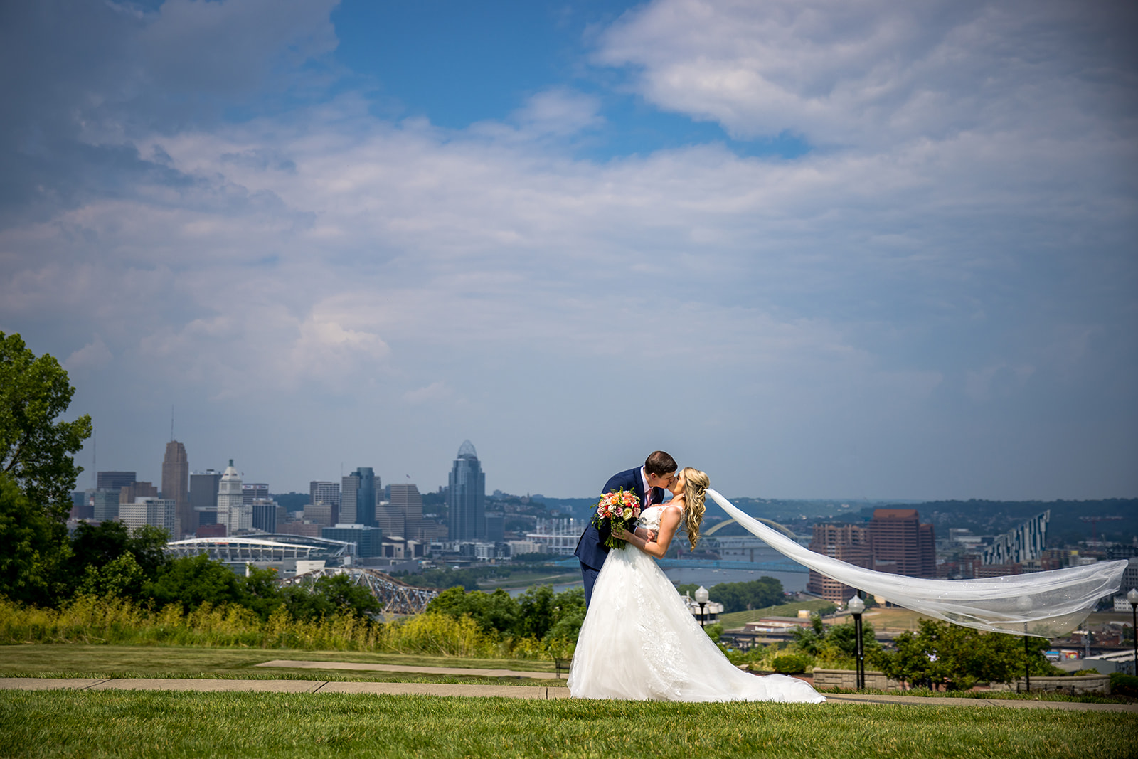 Wedding couple poses in front of Cincinnati Skyline