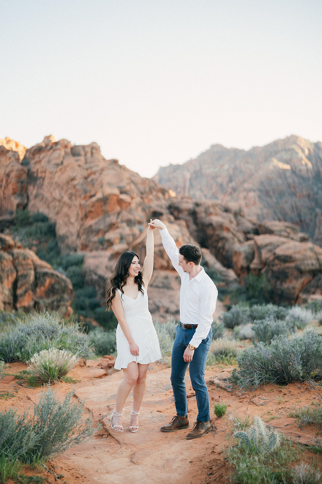 groom spins his fiancé in snow canyon