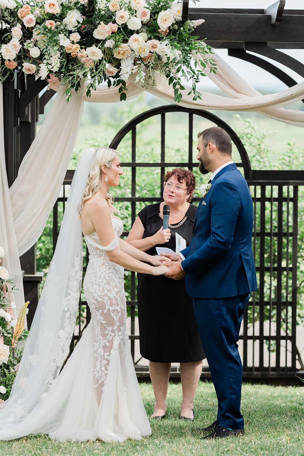 bride and groom holding hands wedding ceremony at farm to table wedding by jess collins photography