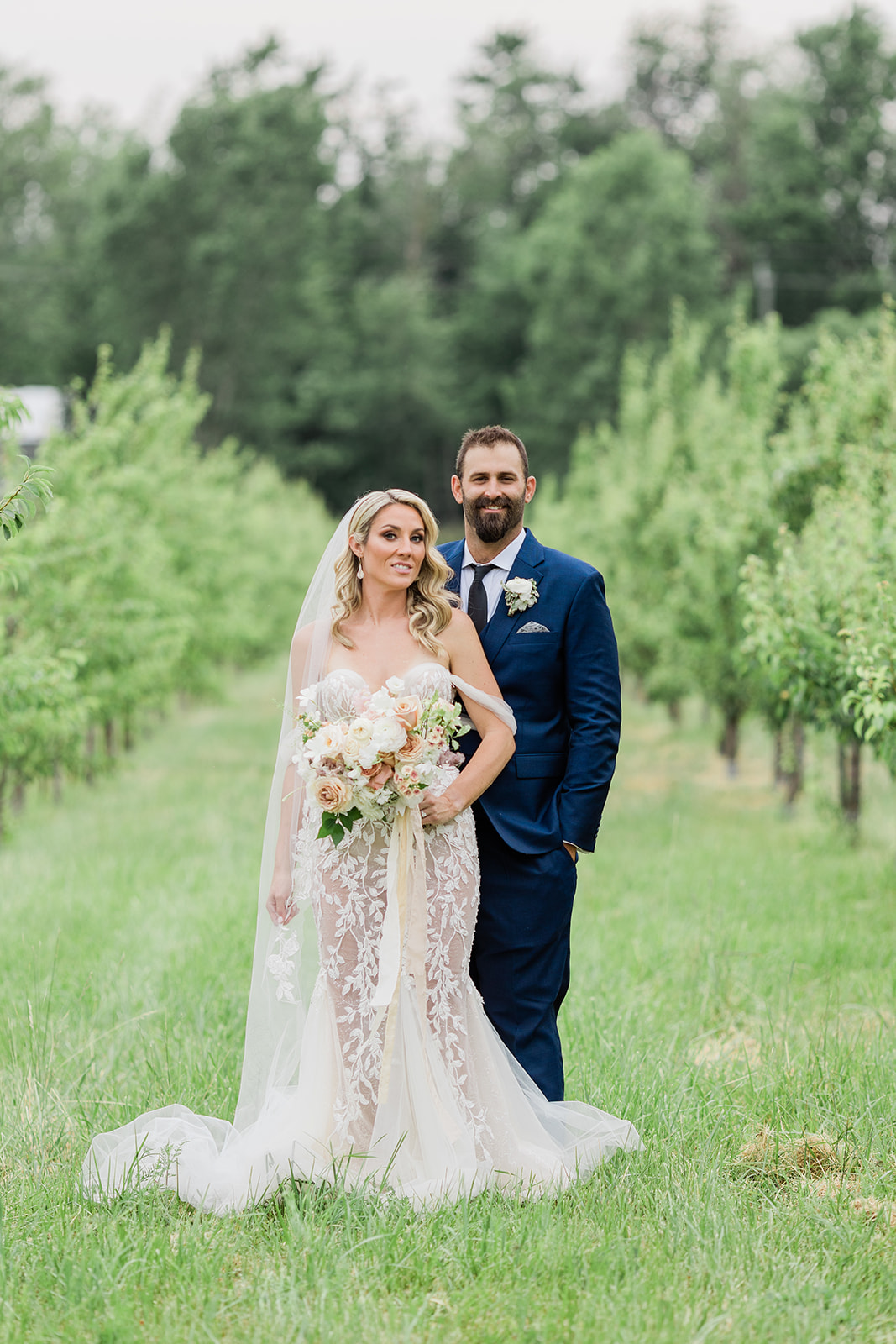 bride and groom in orchard at farm to table wedding by jess collins photography