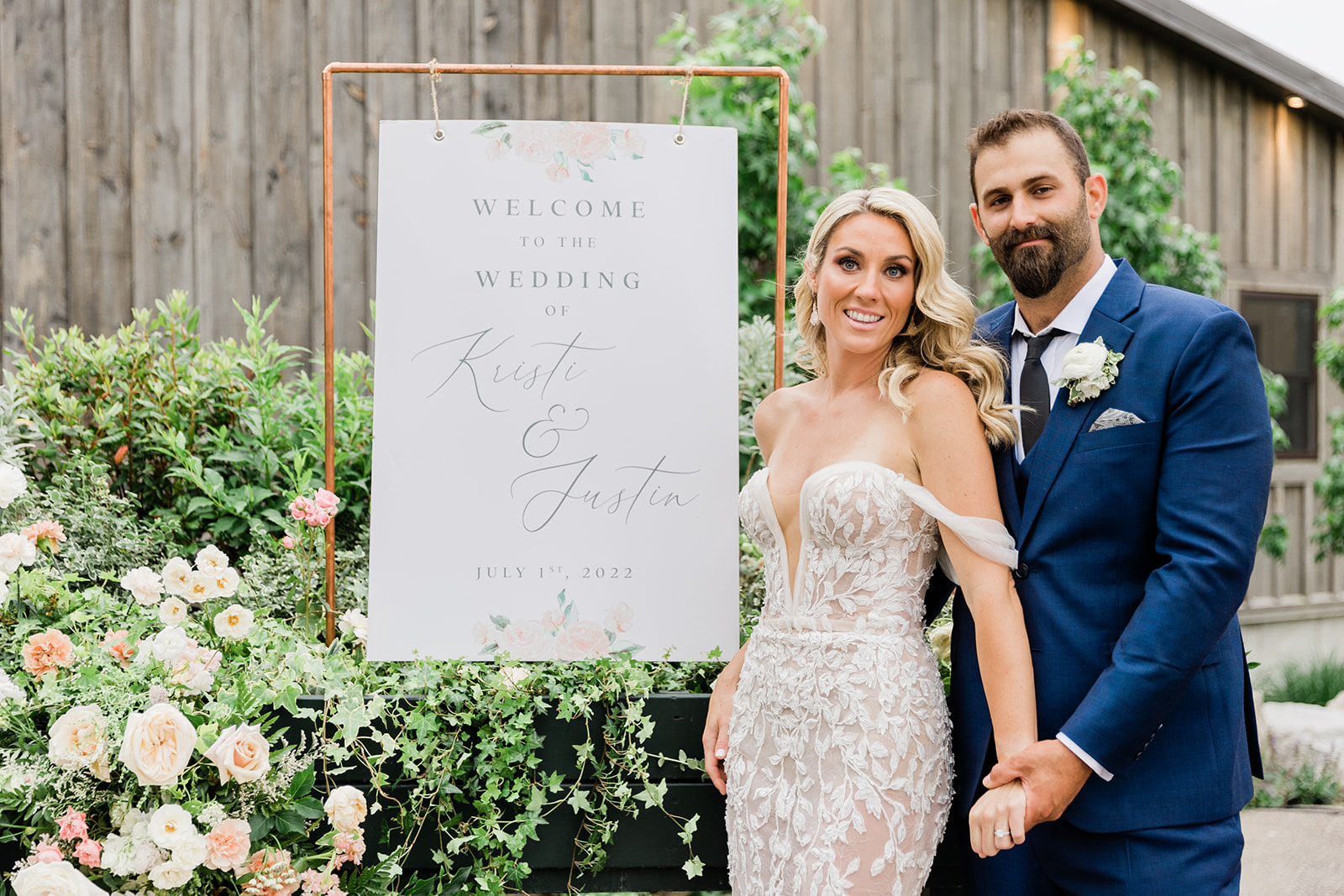 bride and groom with wedding reception sign at farm to table wedding by jess collins photography