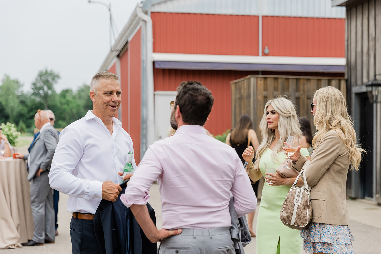 guests having a good time at cocktail hour at farm to table wedding by jess collins photography