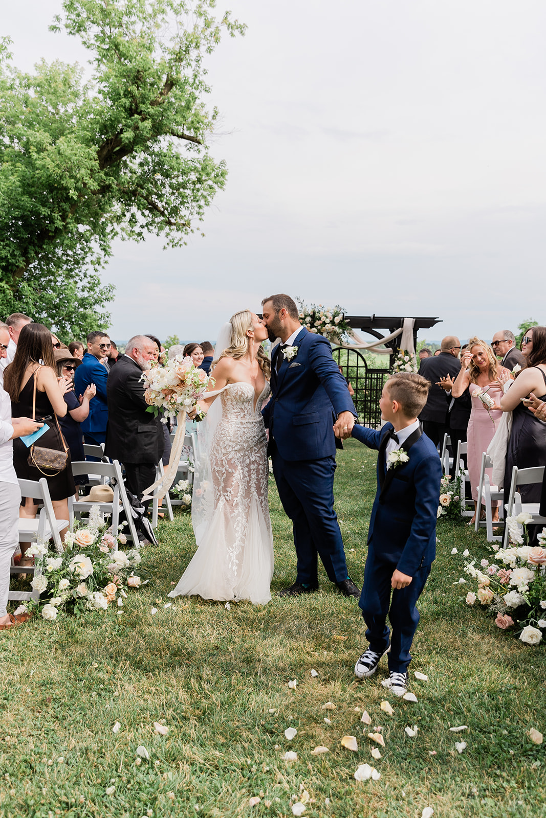 wedding ceremony bride and groom isle kiss at farm to table wedding by jess collins photography