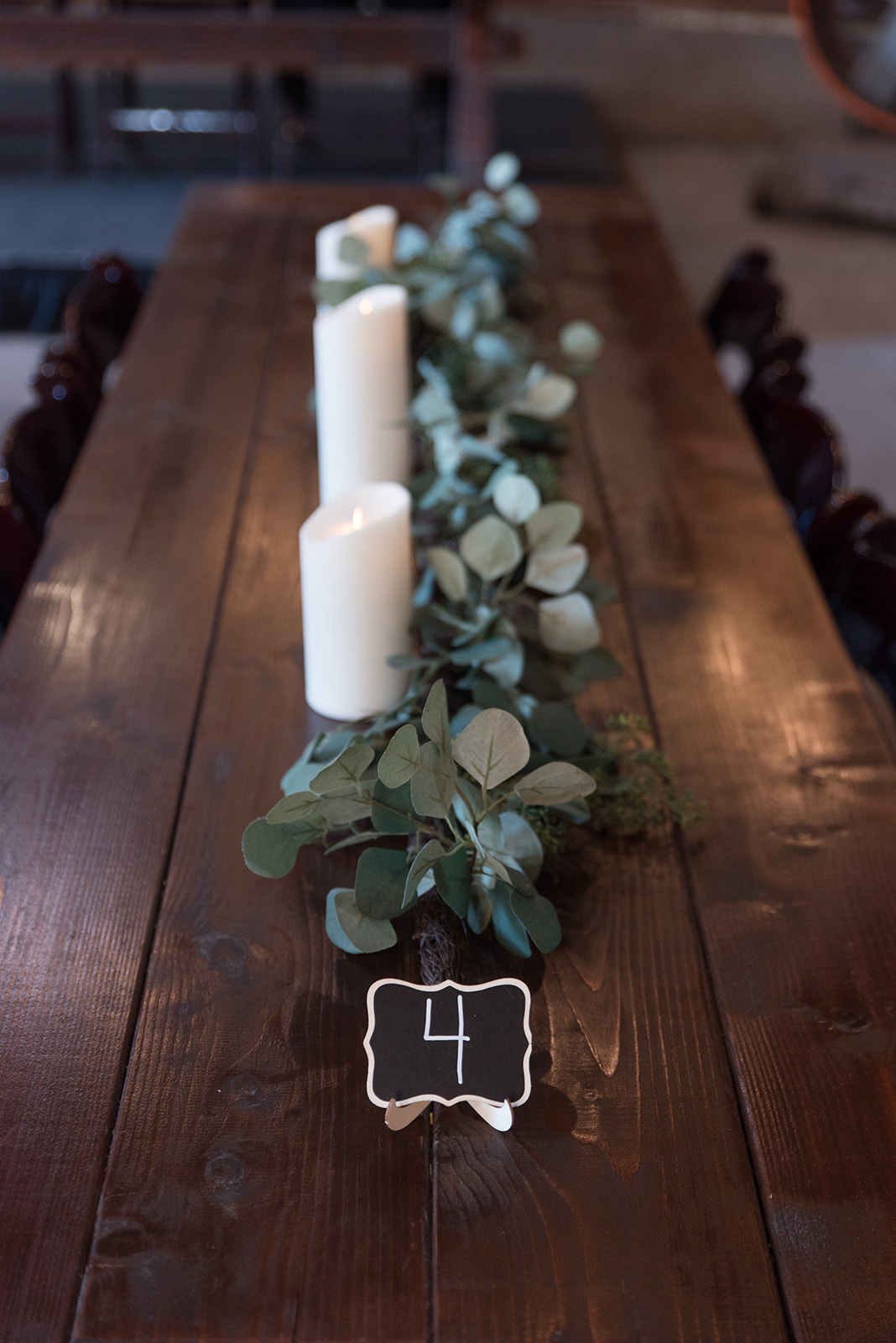 Greenery tablescape with white candles at Erickson Farmstead wedding reception