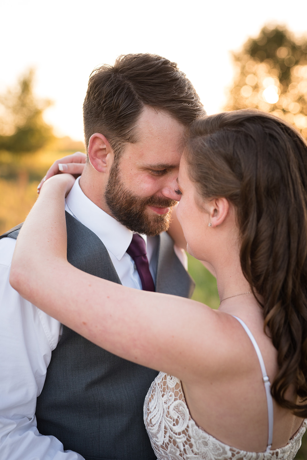 Bride and groom embrace during golden hour right before sunset at Erickson Farmstead in Isanti MN